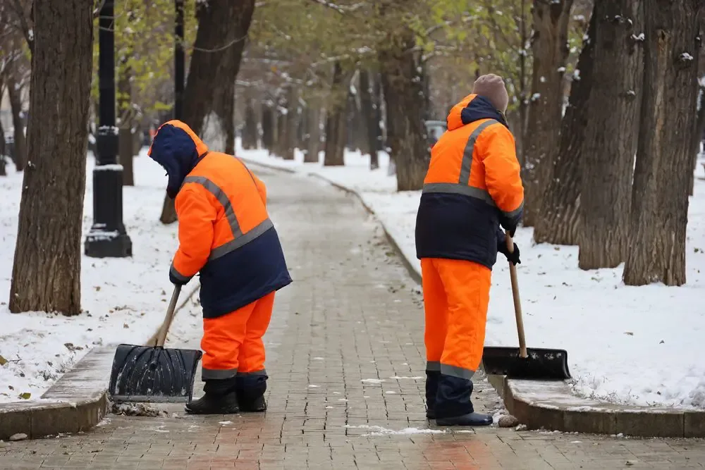 Zwei Mitarbeiter räumen einen Gehweg – Westfalia Winterdienst in Witten